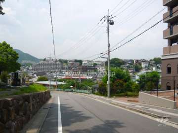 敷地西側の前面道路。緑豊かな高台の住宅地にあり、駅とバス停までにアップダウンがあります。