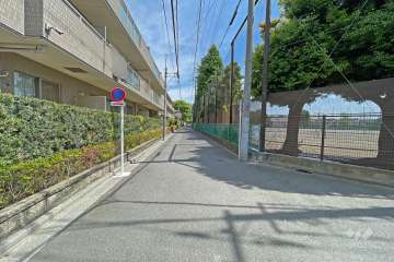 敷地の南東側前面道路（南西側から）。向かいは『開進第一中学校』のグラウンドで開放感があります。