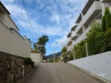 敷地南側の前面道路。周辺は一戸建てが中心に立ち並ぶ高台の住宅地です。