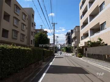 敷地南側の前面道路。周辺はマンションと一戸建てが混在する区画の整った住宅地です。
