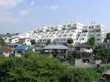 箕面リリーヴィレッジの全景。周辺は一戸建てが中心に建ち並ぶ静かな住宅地です。