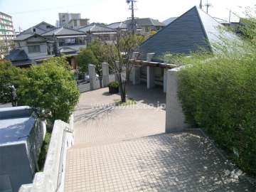 エントランスアプローチ。三角屋根は集会室