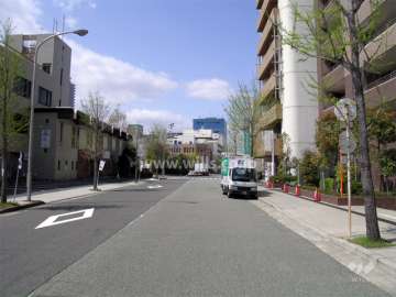 敷地南側の道路。周辺はマンションの他、店舗や事務所も多く立ち並んでいます。