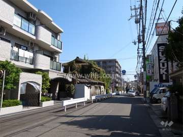 敷地南側の前面道路。周辺には住宅や店舗、事務所などが混在しています。