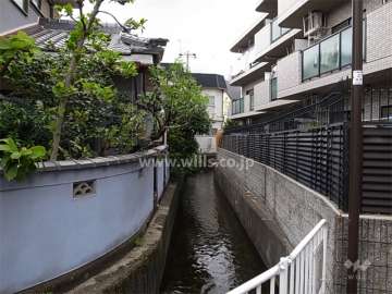 敷地の南側には水路が流れています。周辺は一戸建てが中心に建ち並ぶ住宅地。
