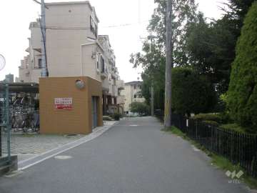 西側の前面道路。周辺は一戸建てとマンションが混在する高台の住宅地です。