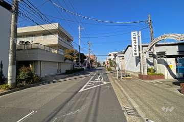 敷地の西側前面道路（南側から）。バス停が目の前にあります。