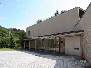 アプローチに向かって庇が伸びるエントランス