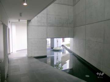 コンクリート打ち放しと水盤がお洒落なエントランスホール