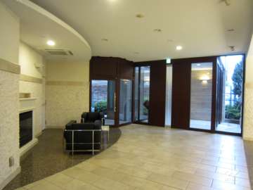 石張りで、壁面には間接照明が設置された豪華なエントランスホール。