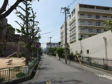 敷地南東側前面道路（北東側から）。敷地南側に公園があります。