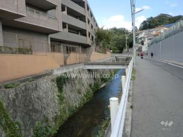 敷地南東側の前面道路。間に水路があります。