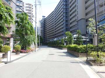 敷地北東側の前面道路。周辺はマンションが多く立ち並ぶ住宅地。