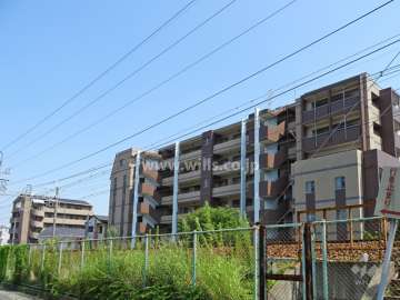 ワコーレ神戸森北町の遠景（北西側から）。マンションの北側には道路を挟んで阪急神戸線が通っています。