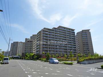 ジオ彩都みなみ坂の遠景。周辺はマンション、一戸建てなどが混在する緑豊かな住宅地です。