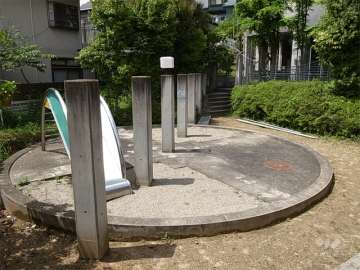 滑り台までがオブジェの様なエントランス横の小さな公園。