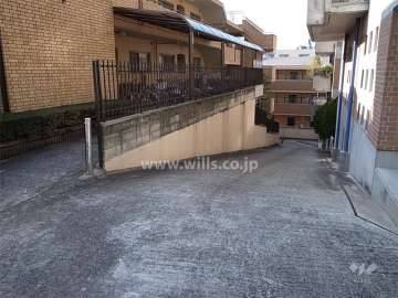 駐車場へのアプローチ。敷地は西方向に下っています。