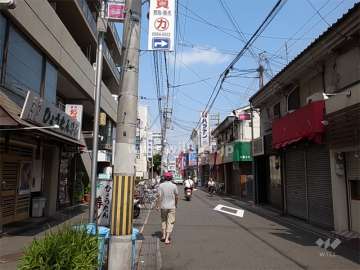 敷地南側は、商店が立ち並ぶ通り。建物1、2階には店舗が入っています。