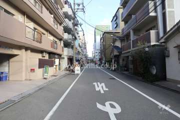 南側前面道路（西側から）店舗が立ち並んでいます。