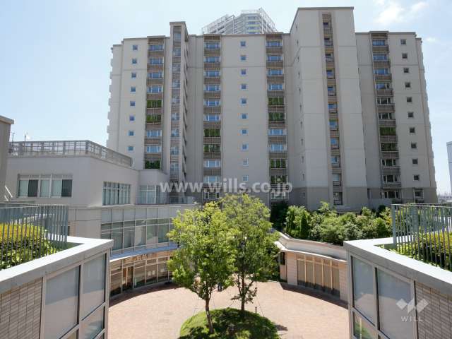 ユニエス南千里丘の外観（北側から）手前に広場、店舗などがあります。