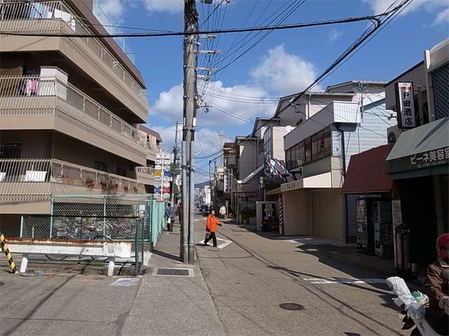 敷地東側の前面道路。商店が立ち並ぶ賑やかな通りです。