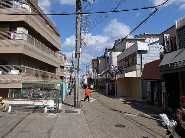 敷地東側の前面道路。商店が立ち並ぶ賑やかな通りです。