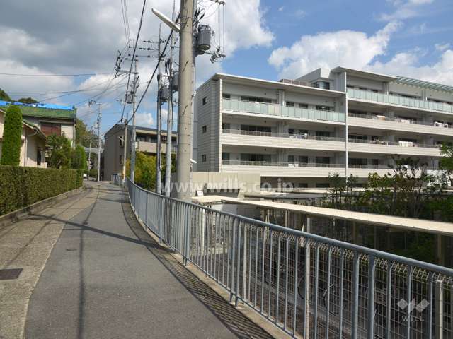 マンション外観の一部と西側前面道路（南側から）