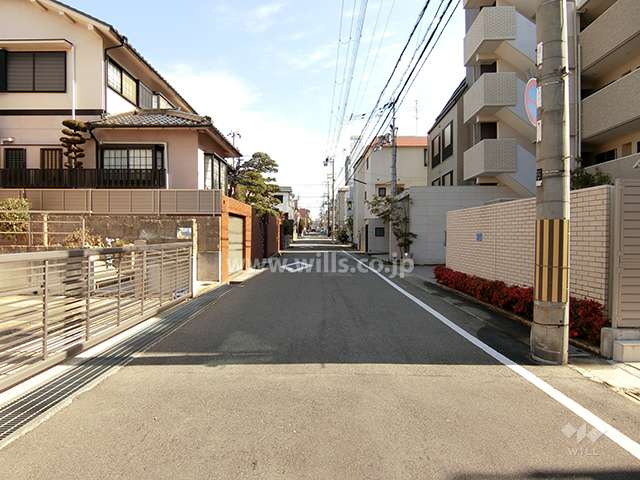 敷地北側の前面道路。周辺はマンションと一戸建てなどが混在する住宅地です。