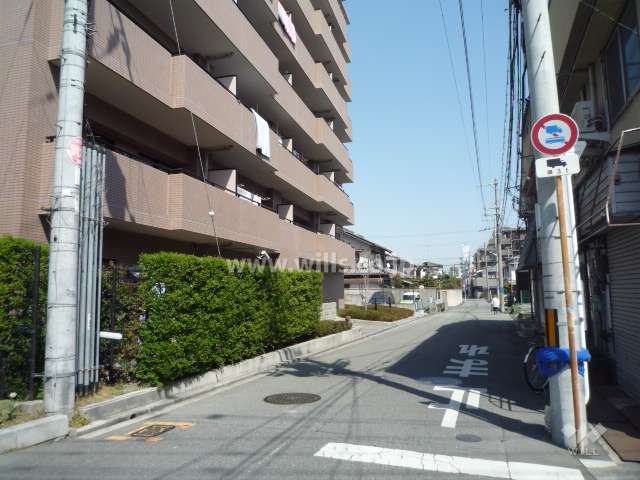 南側前面道路。周辺は一戸建てとマンションが混在する住宅地です。