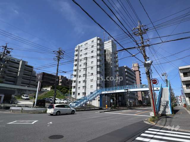 エクセレンス名東の遠景(北東側から撮影)周辺はマンションと商業施設が混在するエリアです。前面道路は片側二車線のバス通りです。