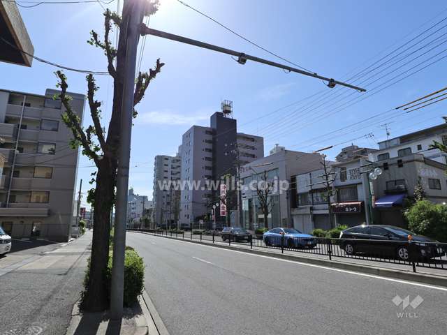 第二東山ハイツの遠景(北西側から)※周辺はマンションや店舗が混在しており、前面道路は片側2車線のバス通りです。