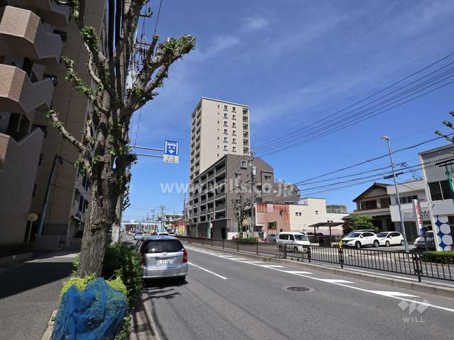 ライオンズ星ヶ丘イーストの遠景(南東側から撮影)周辺はマンションと商業施設が混在するエリアです。前面道路は片側二車線のバス通りです。