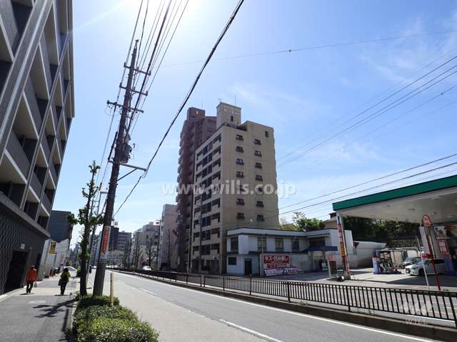 ライオンズマンション虹ヶ丘第2の遠景(北西側から撮影)周辺はマンションと商業ビル等が混在するエリアです。前面道路は片側二車線のバス通りです。