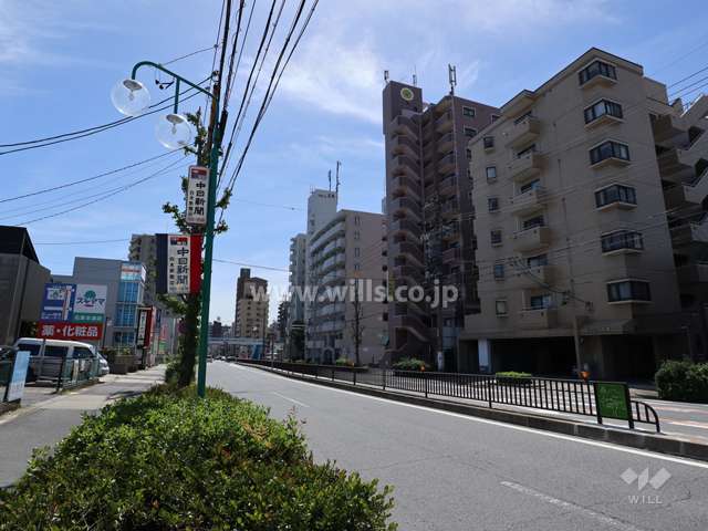 メゾン・ド・エトワールの遠景(北東側から)周辺はマンションと商業ビル等が混在するエリアです。前面道路は片側二車線のバス通りです。