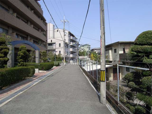 小高い丘の上に立地し、周辺は一戸建てが中心に建ち並ぶ静かな住宅地。
