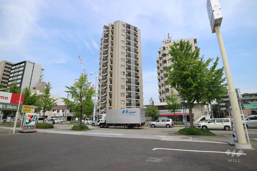 プラウド御器所の遠景。周辺は、住宅の他、店舗や事務所などが混在する街です。