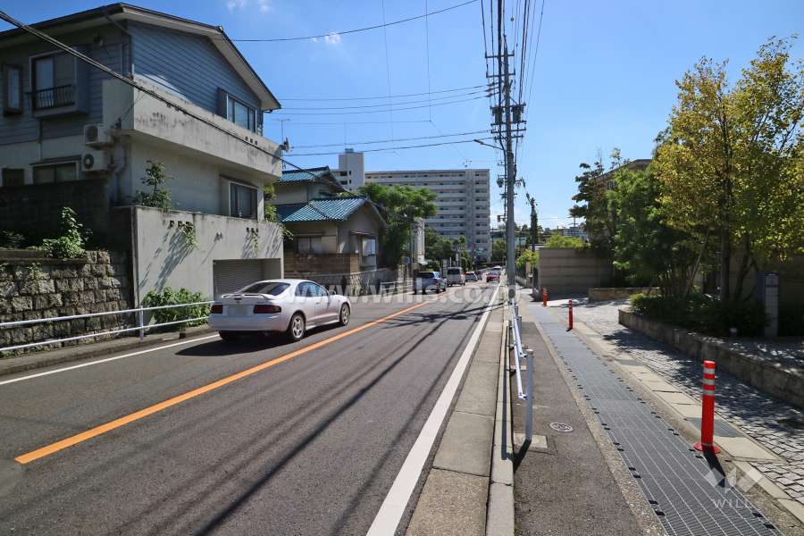 敷地西側の前面道路。坂に面しています。