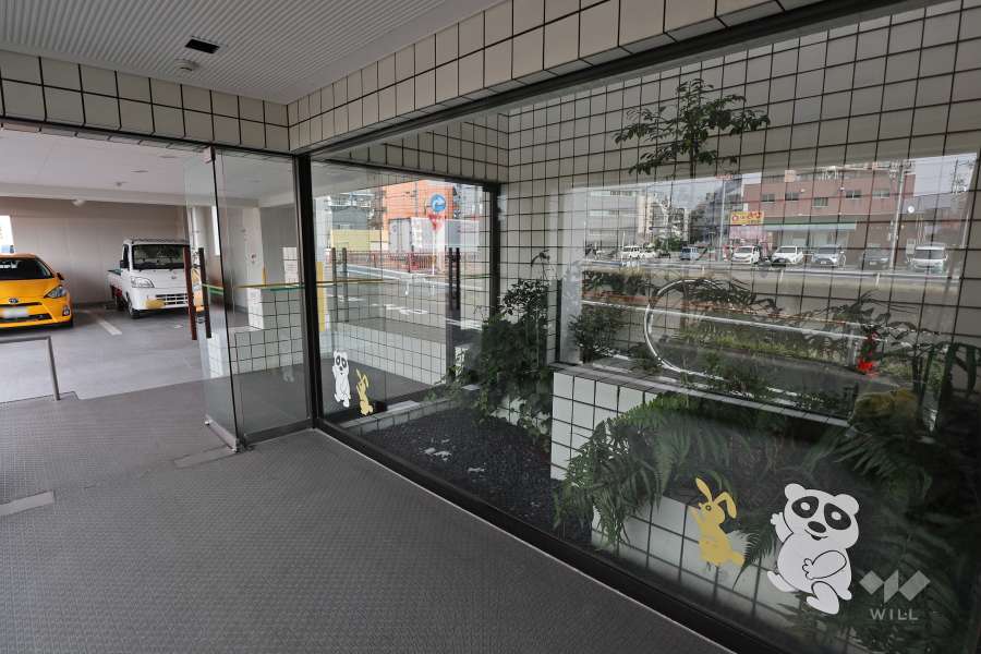 ガラス張りで植栽の設けられたエントランス