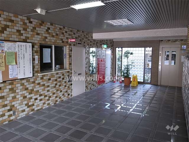 エントランスホール。タイル張りで一部壁面にガラスブロックが用いられています。