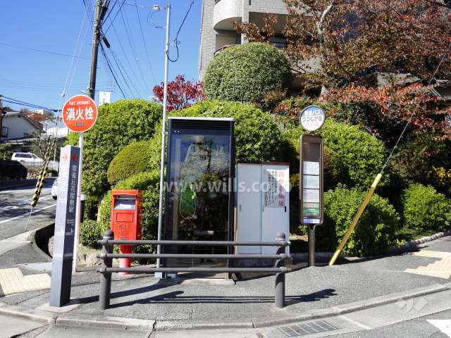 目の前にバス停、電話ボックス、ポストがあります。