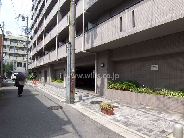 手前から駐車場、ゴミステーション、駐輪場(南西側道路に面す)
