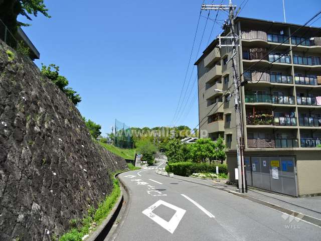 敷地西側の前面道路。周辺はマンションを中心とした住宅街で、左手は千里丘中学校の敷地です。
