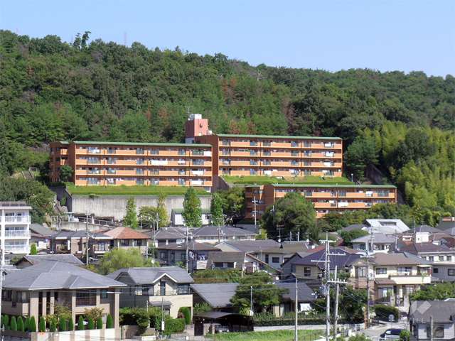 ライオンズマンション宝塚売布の外観（遠景）　やや高台にあり、周囲を山林に囲まれ緑豊か。