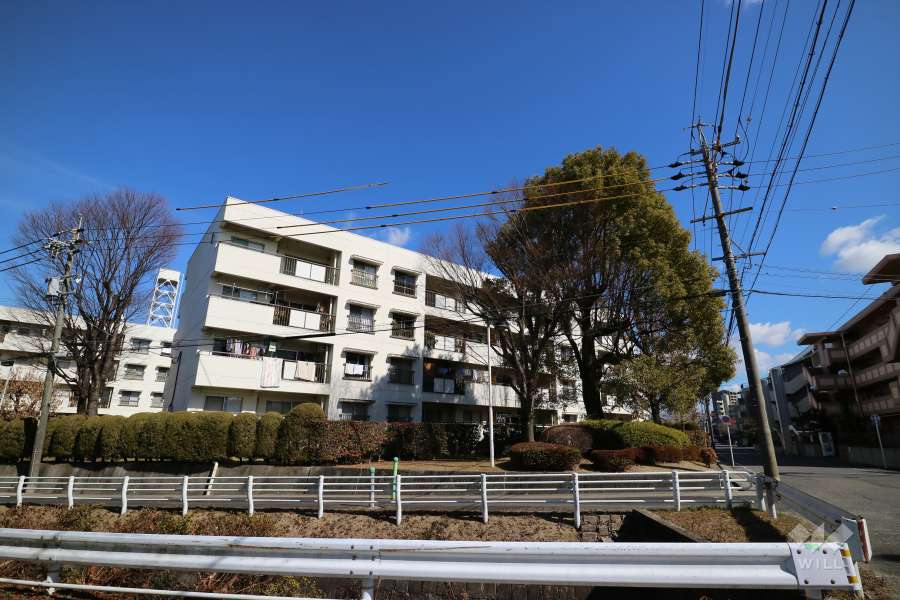 丸山住宅1号棟の遠景。周辺はマンションと一戸建てなどが混在する静かな住宅地です。