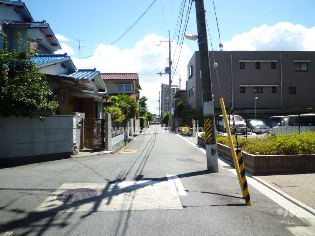 敷地の東側前面道路。周辺は一戸建てが中心に立ち並ぶ区画の整った住宅地です。