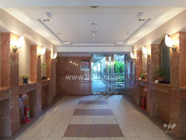 石やタイルが貼られ、折上げ天井のエントランスホール