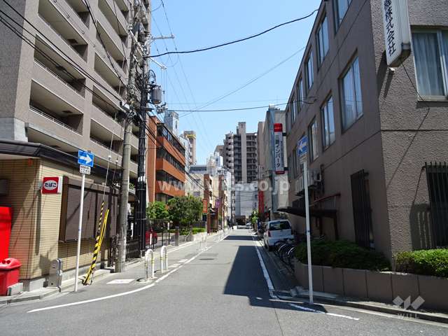 敷地南側の前面道路。近隣商業地域内にあり、マンションの他に、テナントビルなどが混在します。