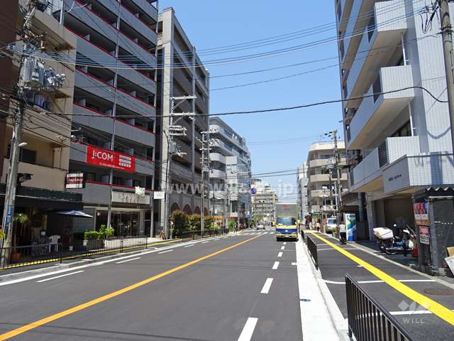 敷地東側の前面道路。周辺には住宅の他、店舗や事務所が建ち並んでいます。