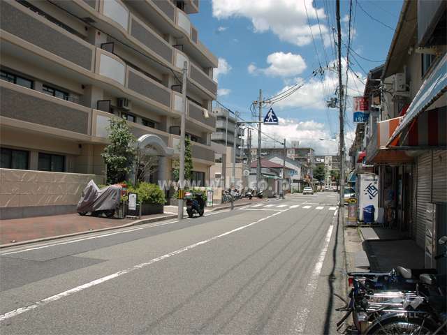 敷地東側の前面道路。通り沿いには店舗が立ち並んでいます。