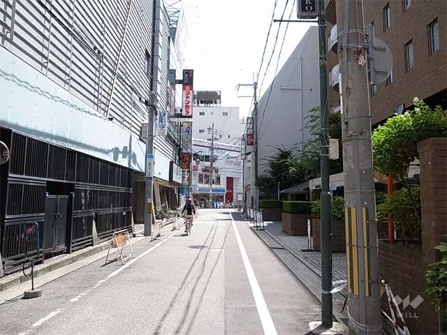 敷地北側の前面道路。周辺には住宅の他、店舗や事務所が多く立ち並んでいます。
